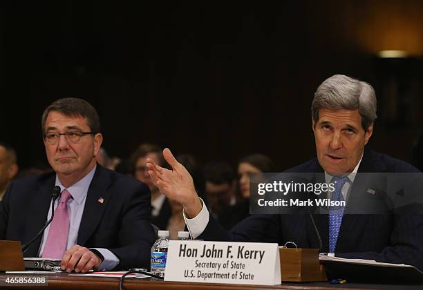 Secretary of State John Kerry testifies while flanked by Defense Secretary Ashton Carter during a Senate Foreign Relations Committee hearing on...