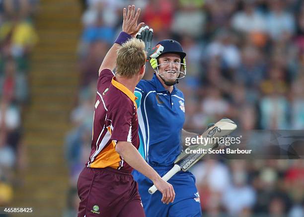 Footballer Jarryd Roughead high fives Brett Lee after scoring runs from his bowling during the Ricky Ponting Tribute Match at Aurora Stadium on...