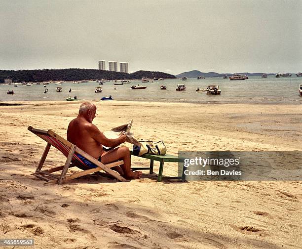 In Pattaya, one of Thailand's most infamous beach resorts on the Gulf of Thailand, a tourist sits out on a deck chair staring out over the bay...