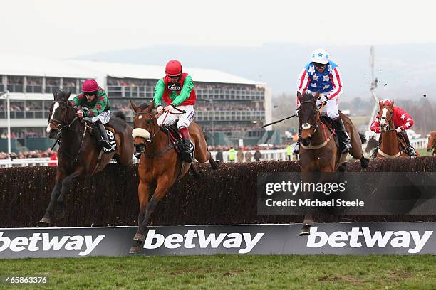 Sam Twiston-Davies riding Dodging Bulletts clears the last fence to win the Betway Queen Mother Champion Steeple Chase from Brian Hughes riding...