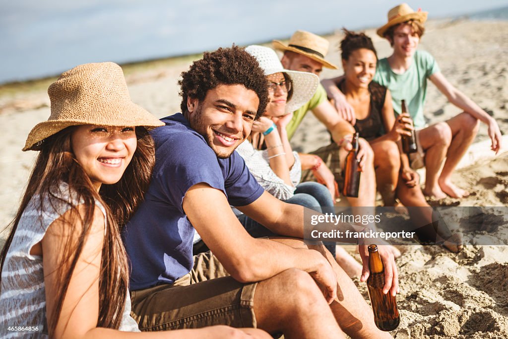 Amici insieme in spiaggia divertirsi con birra