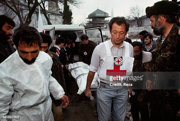 Red Cross workers bring a bodies from a mass killing in Khojaly, Azerbaijan, to a makeshift morgue in Aghdam, Azerbaijan, in February 1992. After the...