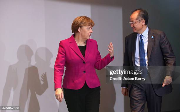 German Chancellor Angela Merkel speaks to World Bank Group President Jim Yong Kim as they arrive for a meeting at the German federal Chancellery on...