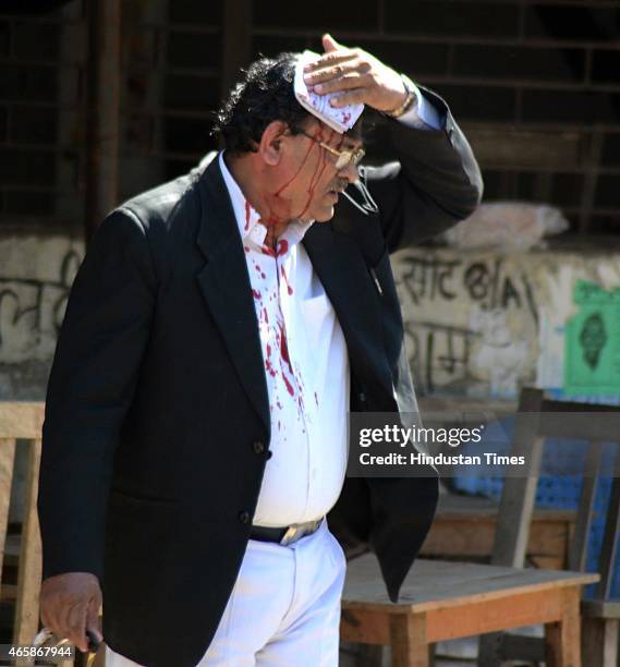 An injured lawyer holding his head to stop the blood during a clash with police outside the district court after a police inspector shot a lawyer in...