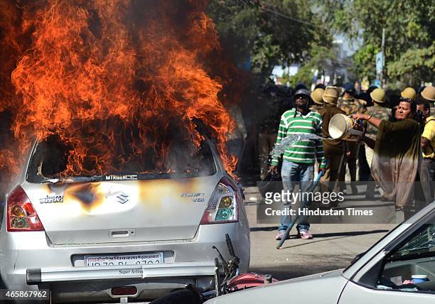 Woman trying to douse the car on fire set alight by angry lawyers outside the district court after a police inspector shot a lawyer in the court...