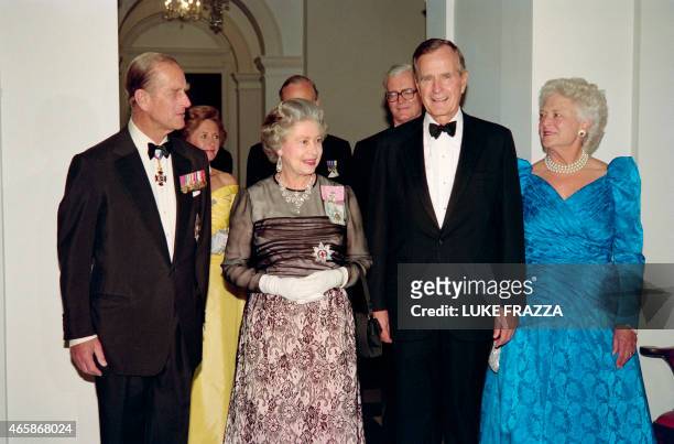 President George Bush and First Lady Barbara Bush arrive on May 16, 1991 at a reciprocal dinner at the British Embassy accompanied by Britain's Queen...