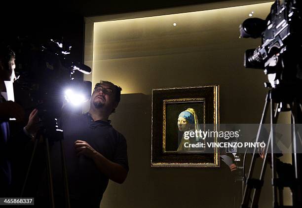 Journalists get ready to film the painting by Johannes Vermeer entitled "the Girl with a Pearl Earring " during a preview of the exhibition " The...