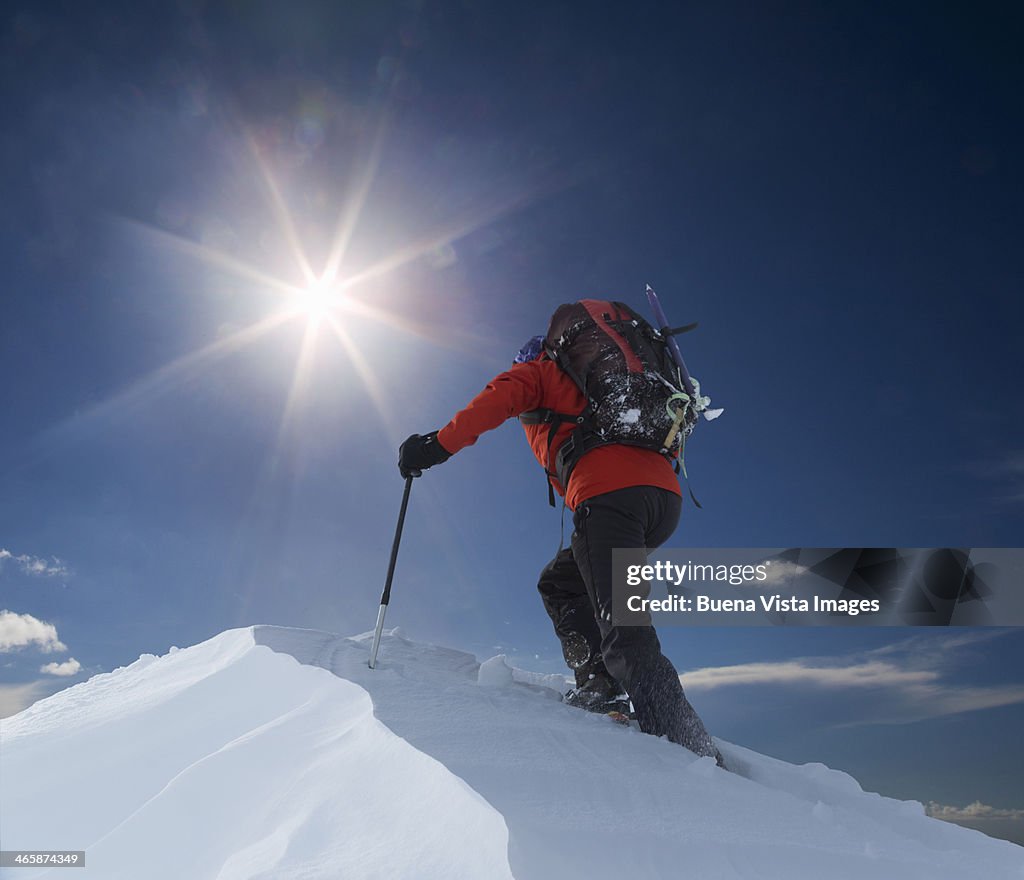 Lone climber reaching a mountain top