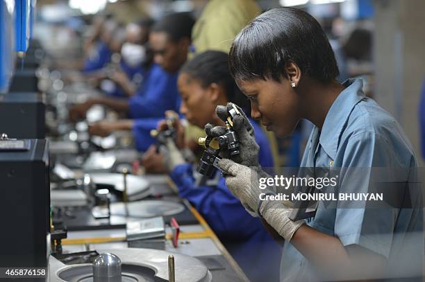 Workers check, cut and polish diamonds at a Diamond cutting and polishing company during the tour by Ghanian President John Dramani Mahama in...