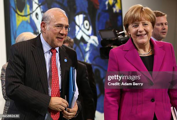 German Chancellor Angela Merkel and Organisation for Economic Cooperation and Development Secretary-General Angel Gurria leave a press conference at...