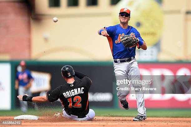 Reid Brignac of the Miami Marlins is out at second base as Matt Reynolds of the New York Mets makes a throw to first base during the fifth inning of...