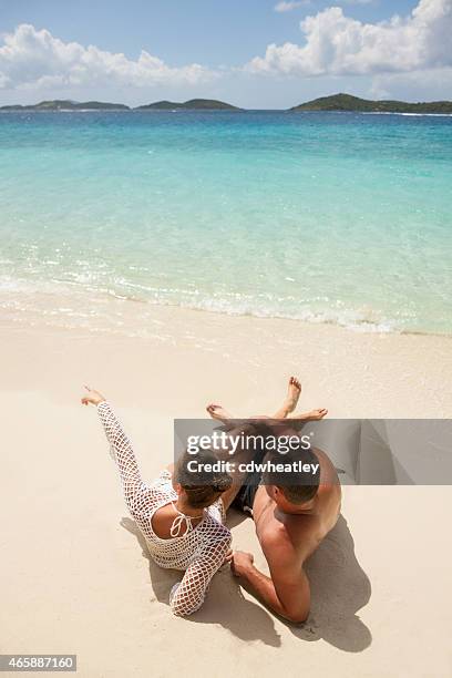 pareja de luna de miel tomar el sol en una playa tropical del caribe. - newlywed fotografías e imágenes de stock