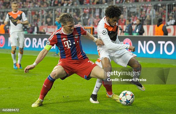 Bastian Schweinsteiger of Bayern Muenchen challenges Luiz Adriano of Shakhtar Donetsk during the UEFA Champions League Round of 16 second leg match...