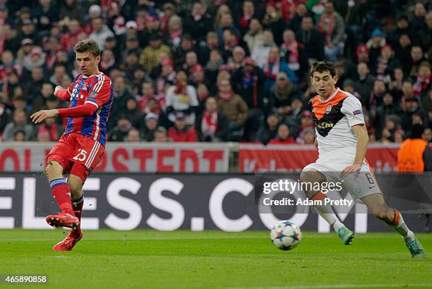 Thomas Mueller of Bayern Muenchen shoots past Taras Stepanenko of Shakhtar Donetsk as he scores their fourth goal during the UEFA Champions League...