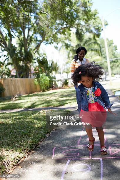 girl doing hopscotch - hopscotch stock pictures, royalty-free photos & images