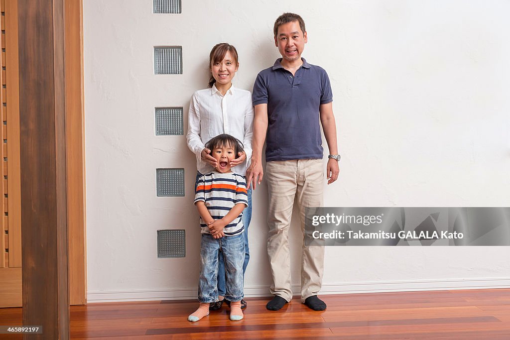 Family with young son making faces