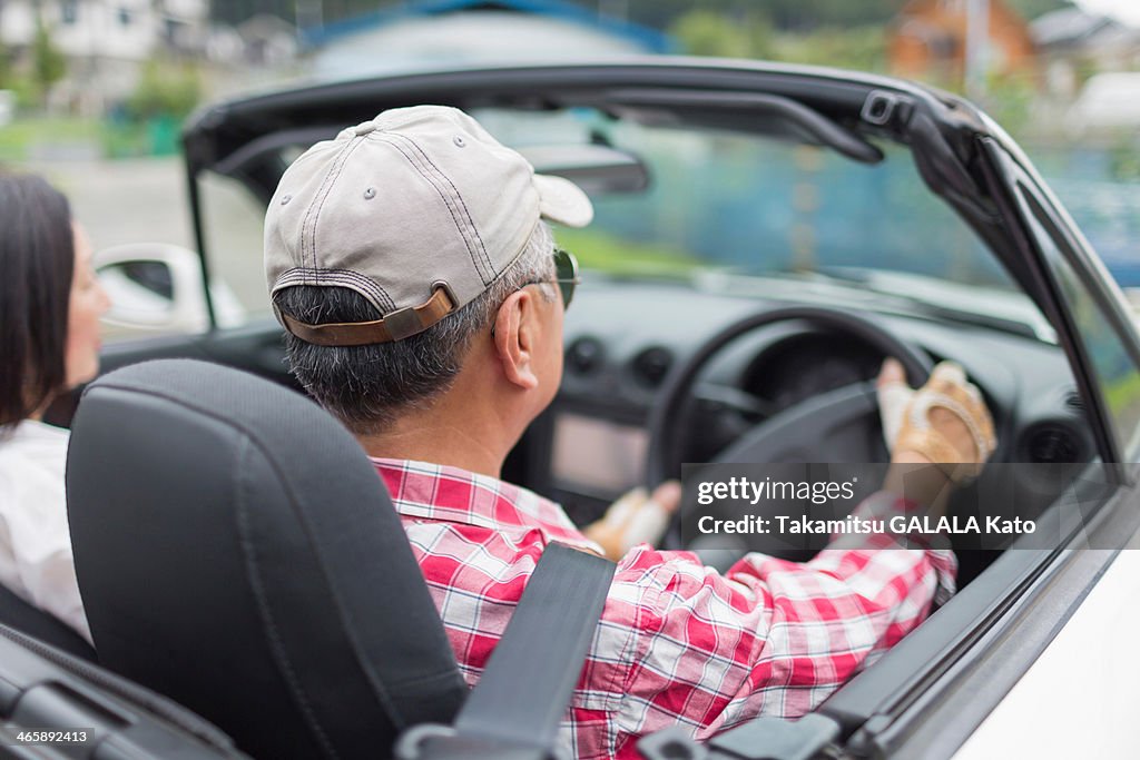 Couple enjoying leisurely drive in sports car