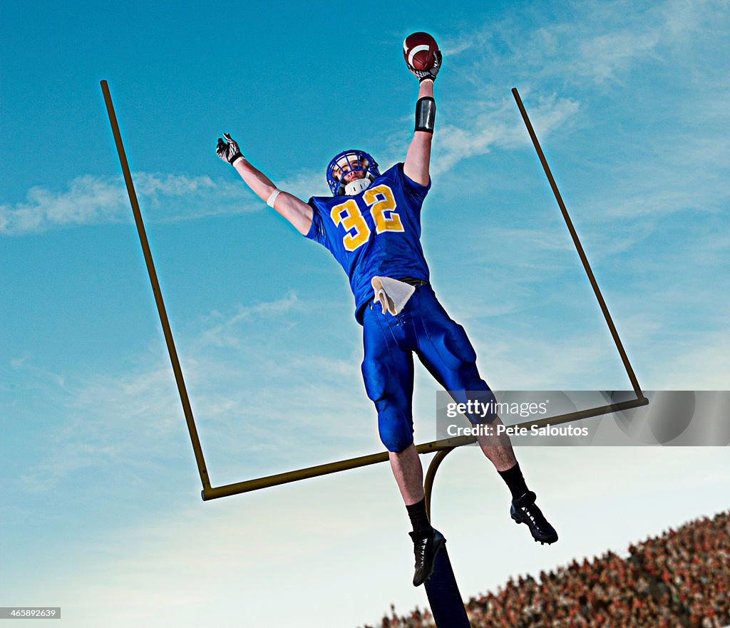 American footballer jumping to catch ball in front of goal