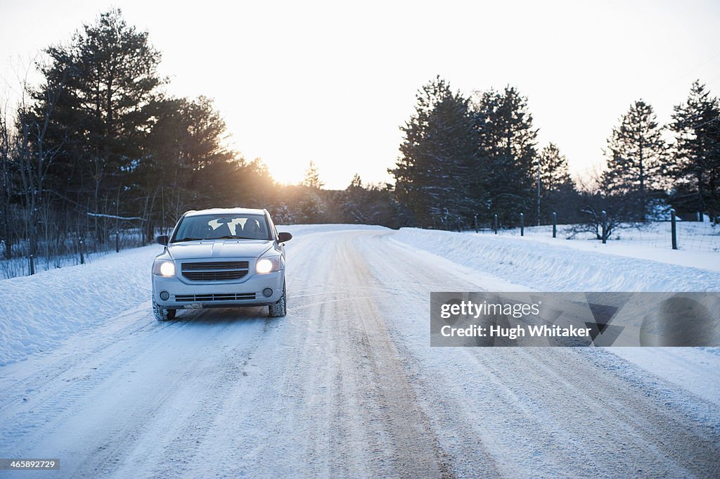 Car driving along road in snow