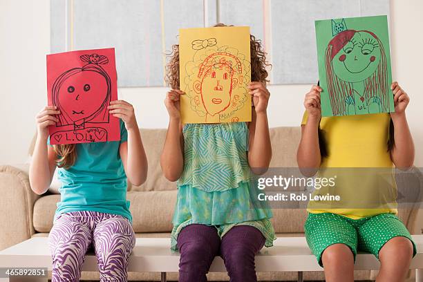 three girls holding pictures over faces - name drawings stock pictures, royalty-free photos & images