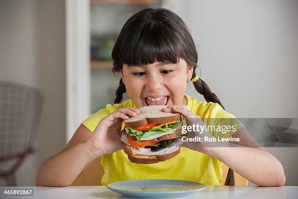 girl biting into sandwich - big sandwich stock pictures, royalty-free photos & images