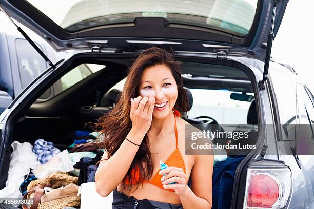 woman putting on suncream, hermosa beach, california, usa - suntan lotion stock pictures, royalty-free photos & images