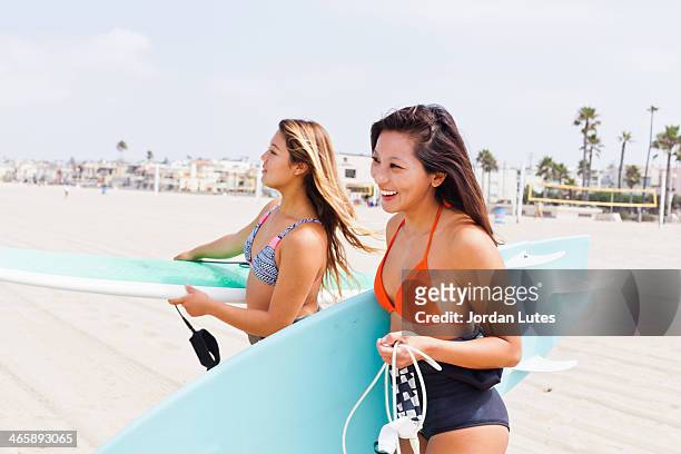 female friends carrying surf boards, hermosa beach, california, usa - hermosa beach stock pictures, royalty-free photos & images