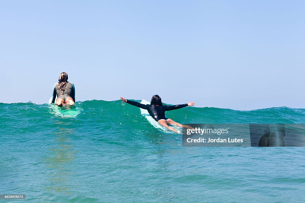 Female friends surfing, Hermosa Beach, California, USA