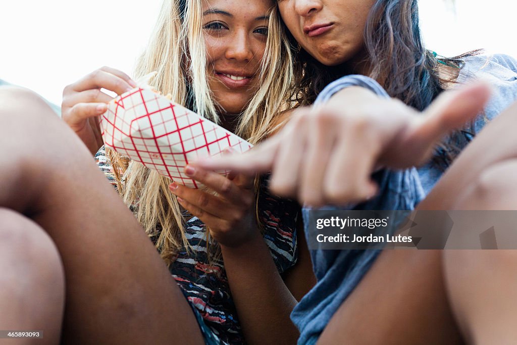 Friends eating takeaway food, Hermosa Beach, California, USA