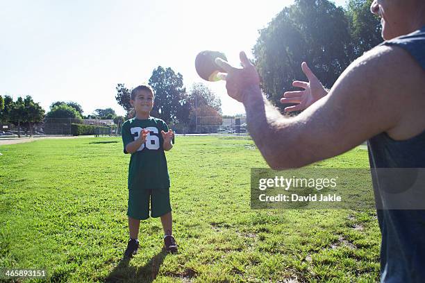 boy and grandfather playing catch with football - grandpa playing catch stock pictures, royalty-free photos & images