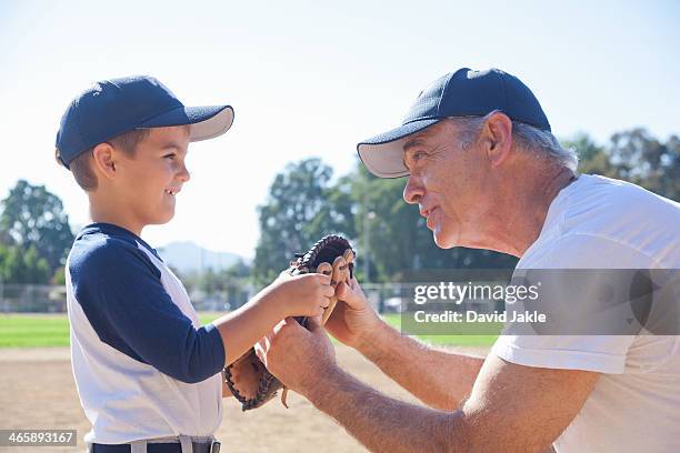 boy and grandfather holding baseball mitt - baseball glove stock pictures, royalty-free photos & images