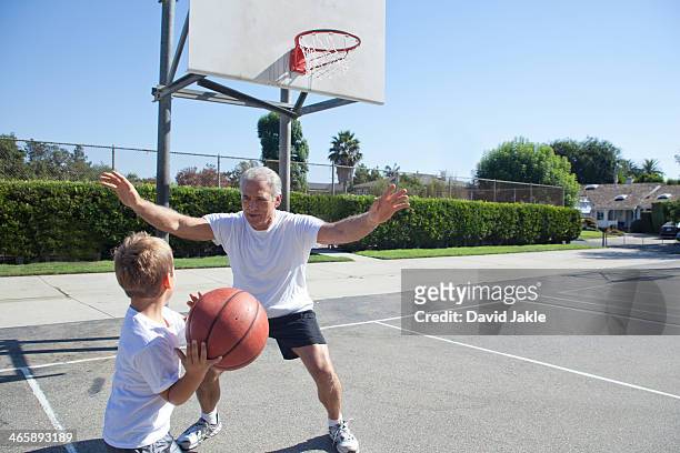 boy and grandfather playing basketball - blocking sports activity stock pictures, royalty-free photos & images