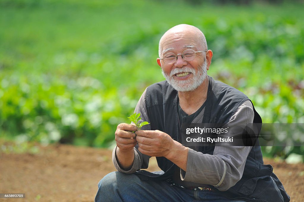 Farmer with leaf smiling at camera