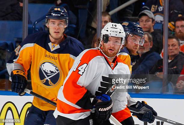 Brayden McNabb and Linus Omark of the Buffalo Sabres look at the puck with Sean Couturier of the Philadelphia Flyers on January 14, 2014 at the First...