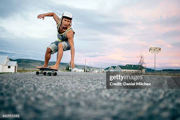 guy turining on his skateboard at sunset. - focus on sport 2013 stock pictures, royalty-free photos & images