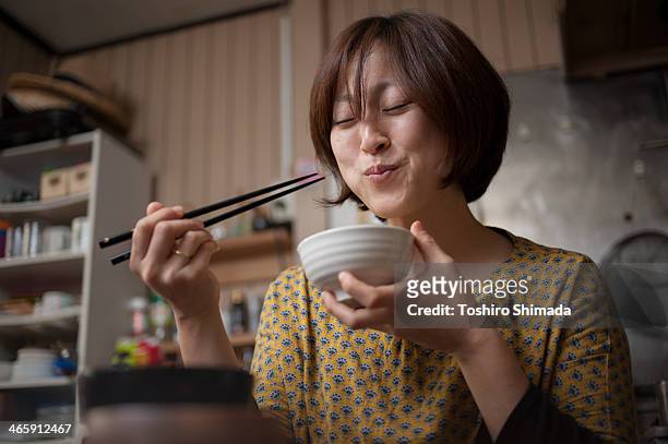 japanese woman eating rice - eetstokje stockfoto's en -beelden