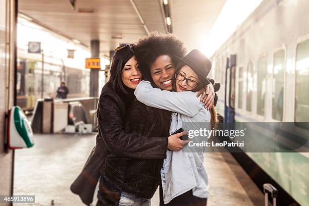 three women friends greet at the train station - train arrival stock pictures, royalty-free photos & images