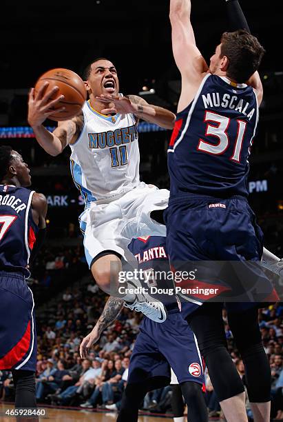 Erick Green of the Denver Nuggets lays up a shot against Mike Muscala of the Atlanta Hawks at Pepsi Center on March 11, 2015 in Denver, Colorado. The...