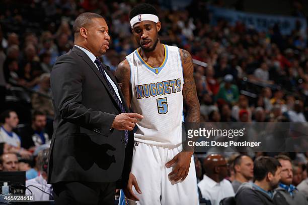 Interim head coach Melvin Hunt of the Denver Nuggets talks with Will Barton of the Denver Nuggets as they face the Atlanta Hawks at Pepsi Center on...