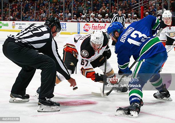 Linesman Jay Sharrers drops the puck as Nick Bonino of the Vancouver Canucks and Rickard Rakell of the Anaheim Ducks face-off during their NHL game...