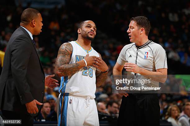 Jameer Nelson of the Denver Nuggets protests a call with referee Brent Barnaky as interim head coach Melvin Hunt of the Denver Nuggets leans in at...