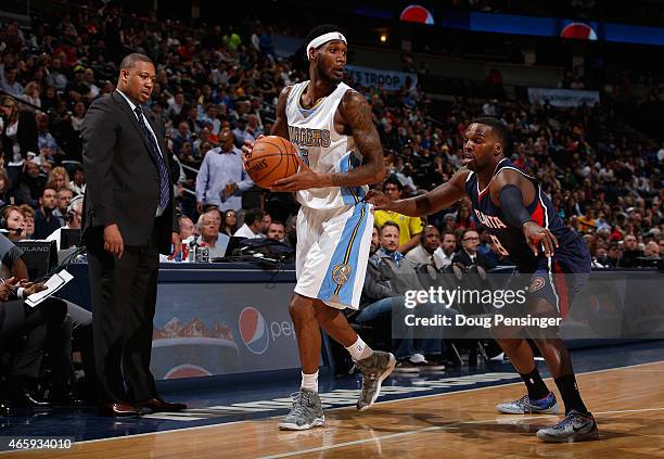 Interim head coach Melvin Hunt of the Denver Nuggets oversees the action as Will Barton of the Denver Nuggets controls the ball against Shelvin Mack...