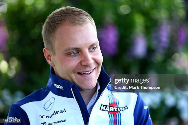 Valtteri Bottas of Finland and Williams smiles as he speaks with members of the media in the paddock during previews to the Australian Formula One...