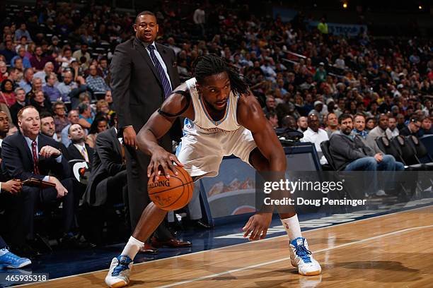 Kenneth Faried of the Denver Nuggets controls the ball against the Atlanta Hawks as Interim head coach Melvin Hunt of the Denver Nuggets oversees the...