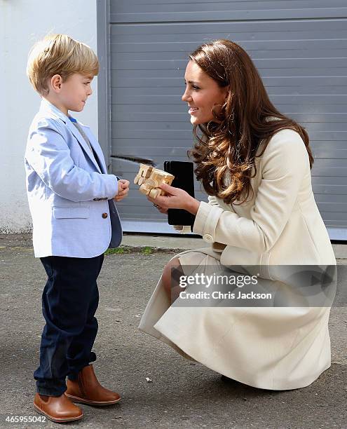 Catherine, Duchess of Cambridge is presented with a train for Prince George by actor Oliver Barker during an official visit to the set of Downton...