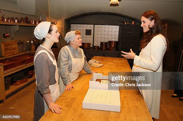 Catherine, Duchess of Cambridge chats to actresses Sopie McShera and Lesley Nicol during an official visit to the set of Downton Abbey at Ealing...