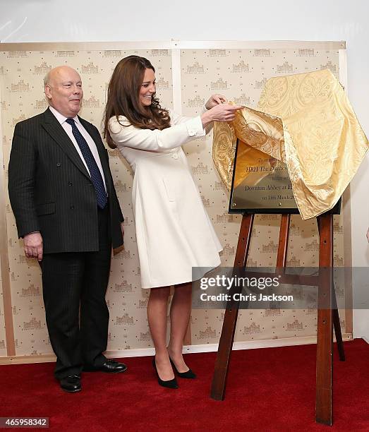 Catherine, Duchess of Cambridge unveils a plaque as Lord Julian Fellowes looks on during an official visit to the set of Downton Abbey at Ealing...