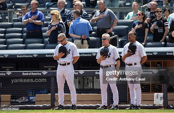 Manager Joe Girardi, first base coach Mick Kelleher and bench coach Tony Pena of the New York Yankees stand outside the dugout during the National...