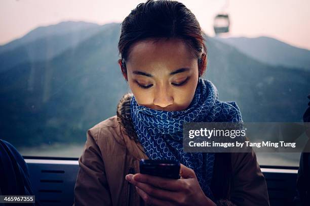 Young lady using smartphone in cable car