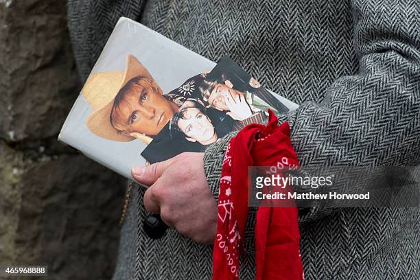 Mourner holds pictures during the funeral of Visage star Steve Strange at All Saints Church on March 12, 2015 in Porthcawl, Wales. Steve Strange was...
